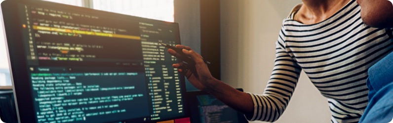 People looking at code on a computer screen